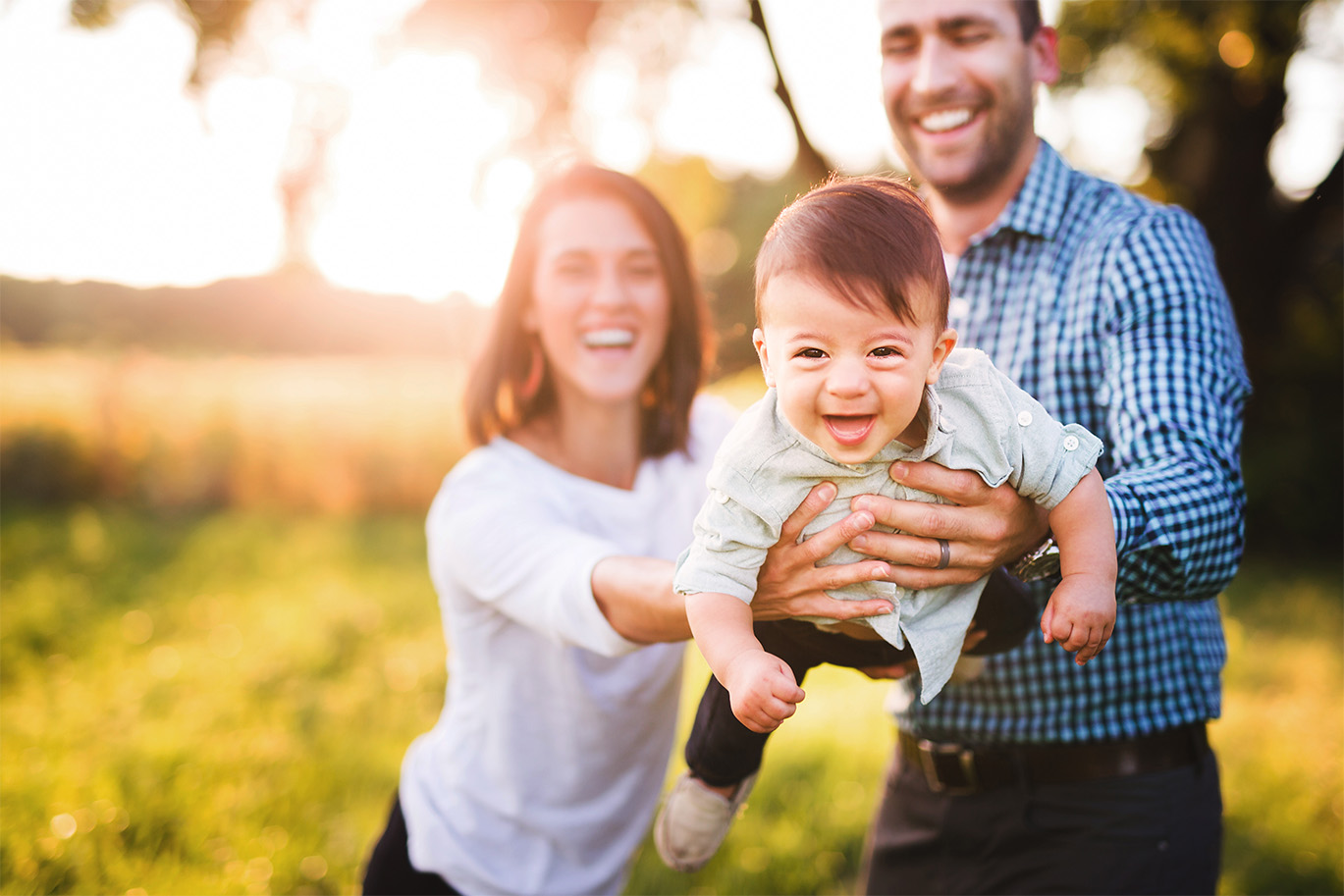 Young family playing with their toddler outside